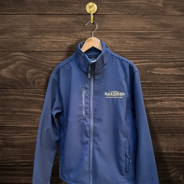 The Black Farmer Softshell Jacket in navy blue, featuring a sleek design with a zip closure and embroidered logo, displayed on a wooden hanger.